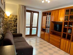 a living room with a couch and a television at Casetta IV Vico- Chianalea in Scilla