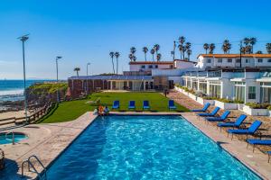 a pool with chairs and the ocean in the background at Dog-Friendly Suite with Kitchenette, Heated Outdoor Pool, Hot Tub, Terrace, AC in Rosarito