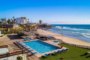 a swimming pool next to a beach and the ocean at Dog-friendly Home with Partial Ocean View, Heated Pool, Rooftop Terrace in Rosarito