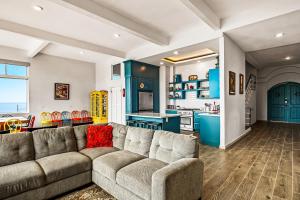 a living room with a couch and a kitchen at Tropical Retreat with Ocean Views - Steps from the sand with alfresco dining in Rosarito