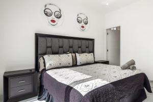 a bedroom with a bed with two masks on the wall at Dog-friendly home 3 rows to beach with rooftop deck, pool, & kitchen in Rosarito +46 photos