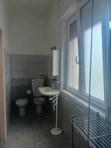 a bathroom with a toilet and a sink and a window at B&B Villa AVE in Seriate