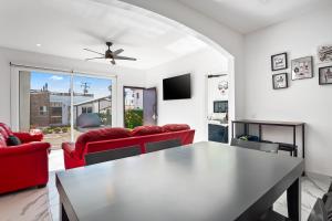 a living room with red couches and a table at Dog-friendly home 3 rows to beach with rooftop deck, pool, & kitchen in Rosarito