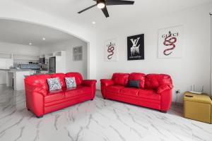 two red couches sitting in a living room at Dog-friendly home 3 rows to beach with rooftop deck, pool, & kitchen in Rosarito