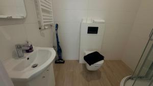 a white bathroom with a toilet and a sink at STUDIO LEŚNE z DUŻYM TARASEM nad Zalewem in Serock +16 photos