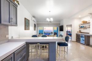 a kitchen with a large island with bar stools at Dog-Friendly Ocean-view Villa with Patio, Outdoor Pool, Streaming, partial AC in Rosarito