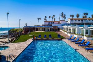 a pool with chairs and the ocean in the background at Airy, Beach-View Dog-Friendly Villa with Patio, Outdoor Pool, Streaming, AC in Rosarito