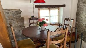 a dining room table with a vase of flowers on it at RIVER resort in Varallo +9 photos