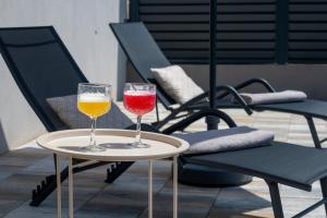 two wine glasses on a table next to a chair at Villa La Lana in Mostar