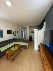 a living room with a couch and a flat screen tv at Home Two Brothers in Bar