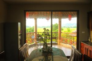 a dining room table with a view of a balcony at Y Van Cac Homestay Ninh Binh Art Heritage Rice Field in Ninh Binh
