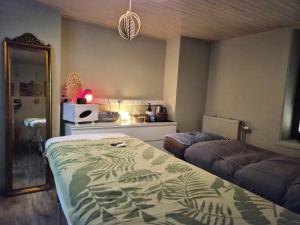 a bedroom with a bed and a kitchen with a microwave at Tiny House Chimay in Chimay
