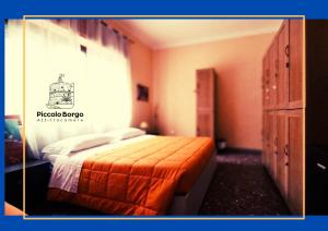 a bedroom with a bed with an orange bedspread at Piccolo Borgo Affittacamere BIKE FRIENDLY in Taranto