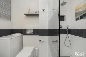 a white bathroom with a shower and a toilet at Marítimo D&D Apartments Porta Mare in Dziwnówek +60 photos