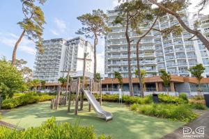 a playground in front of a large apartment building at Marítimo D&D Apartments Porta Mare in Dziwnówek