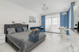 a bedroom with a bed and a table in it at Marítimo D&D Apartments Porta Mare in Dziwnówek