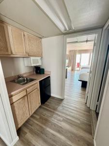 a kitchen with a sink and a room with a bed at Flamingo Motel in Ocean City