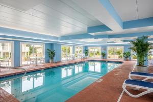 a swimming pool in a hotel with blue walls and windows at Flamingo Motel in Ocean City
