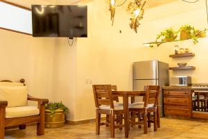 eine Küche mit Tisch, Stühlen und Kühlschrank in der Unterkunft QUINTA BERNAL in Lo de Marcos