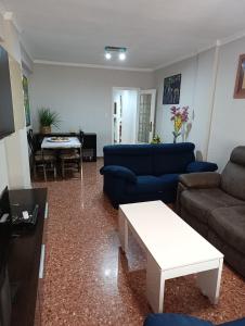 a living room with a blue couch and a table at Aroca in Elda