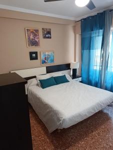 a bedroom with a large bed with blue pillows at Aroca in Elda