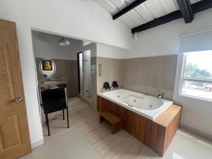 a large bathroom with a tub and a mirror at Hotel Cerro Bravo in Fredonia