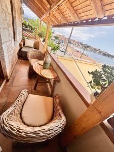 a balcony with wicker chairs and a view of the ocean at Jasmine Stoupa in Stoupa