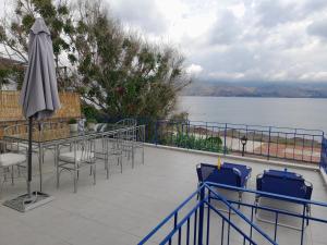 a patio with chairs and a table and an umbrella at The Blue Door in Lixouri