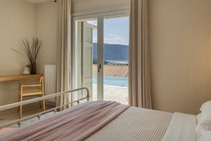 a bedroom with a bed and a sliding glass door at Fiscardo View Villas in Fiskardo +215 photos