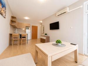 a living room with a table and a kitchen at Sunny Day 3 - Pool and Chill in Sunny Beach