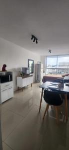 a living room with a table and a kitchen at Monoambiente como en casa in Montevideo