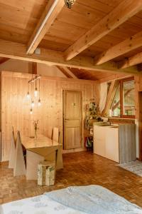 a kitchen with a wooden ceiling with a table in it at ECO-CHALET Bel Oiseau - Saint-Ursanne in Saint-Ursanne