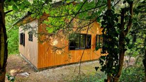a small orange and white building in the woods at Chalet Côtes de Meuse in Deuxnouds-aux-Bois