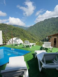 a resort with a pool and chairs and a mountain at Mtirala Yurt in Batumi +33 photos