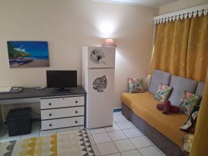 a small room with a desk and a bed with a desk at Charmant Studio CRISTAL COCO Les Trois-Îlets Martinique in Les Trois-Îlets