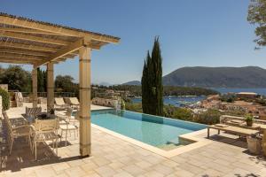 a patio with a swimming pool and a pergola at Fiscardo View Villas in Fiskardo