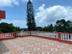 a balcony with a white fence and a tree at Terraza Marina in Bajos de Haina
