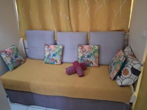a bed with a bunch of pillows on it at Charmant Studio CRISTAL COCO Les Trois-Îlets Martinique in Les Trois-Îlets