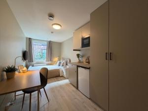 a small apartment with a bedroom and a desk and a bed at Kongens Gate Rooms in Kristiansand