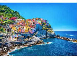 a group of colorful houses on a cliff next to the ocean at Villa LUCCA in Altopascio
