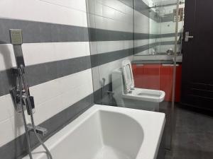 a bathroom with a white sink and a toilet at Raintree Villa in Vythiri