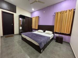 a bedroom with a large bed with purple walls at Raintree Villa in Vythiri