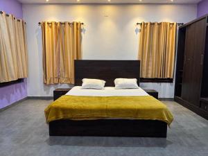 a bedroom with a large bed with a yellow blanket at Raintree Villa in Vythiri