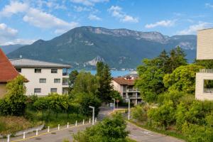 a view of a city with a mountain at Lac arte postale- Terrasse, grand garage privatif, borne de recharge en électricité, climatisation murale un appareil dans chaque pièce et unité extérieure, lit-parapluie pour bébé possible in Annecy