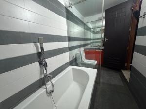 a bathroom with a bath tub and a toilet at Raintree Villa in Vythiri