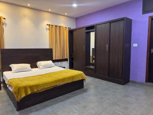 a bedroom with a large bed and a cabinet at Raintree Villa in Vythiri +7 photos