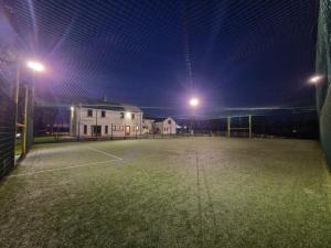 an empty tennis court at night with lights on at Breesy Centre Apartment in Donegal +2 photos