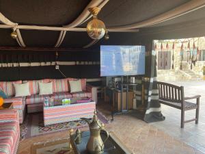 a living room with a couch and a flat screen tv at Horizon 3 Villa in Amman