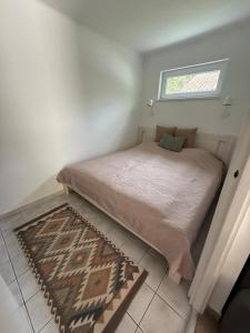 a small bedroom with a bed and a window at Hegylakó vendégház in Balatonkenese