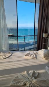 a bedroom with a bed and a view of the ocean at Sun Boutique Pomorie in Pomorie